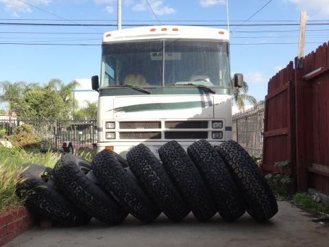 1995 Chevrolet P30 1 Ton - Step Van - A row of tires is lined up in front of a large RV motorhome.