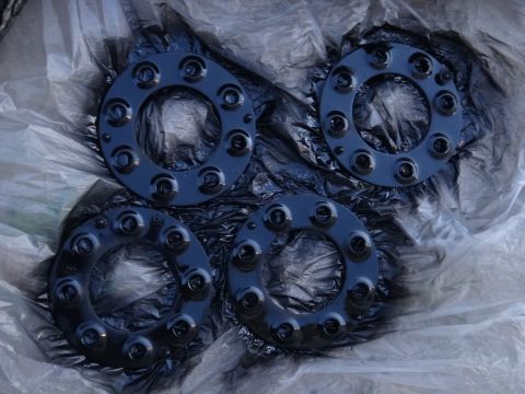 1995 Chevrolet P30 1 Ton - Step Van - Four black wheel spacers are laid out on plastic sheeting, likely after being painted.