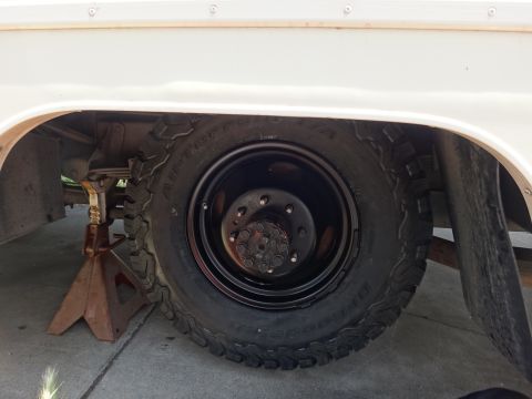 1995 Chevrolet P30 1 Ton - Step Van - Close-up of a wheel and tire on a white step van, supported by a jack stand.
