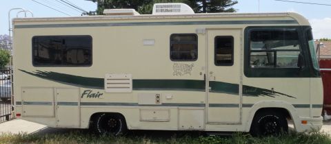 1995 Chevrolet P30 1 Ton - Step Van - Side profile of a cream Fleetwood Flair Class A motorhome with green swoosh graphics and roof AC unit.