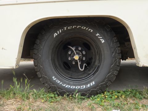 1995 Chevrolet P30 1 Ton - Step Van - Close-up of a white step van's wheel and tire, showing the BFGoodrich All-Terrain T/A tread pattern.