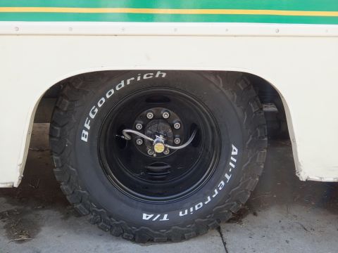 1995 Chevrolet P30 1 Ton - Step Van - Close-up of a tire and wheel assembly on a vehicle with green and yellow stripes.