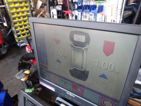 1995 Chevrolet P30 1 Ton - Step Van - A wheel balancing machine displays weight measurements for tire balancing.
