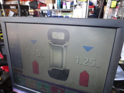1995 Chevrolet P30 1 Ton - Step Van - A wheel balancing machine displays weight measurements for tire balancing.