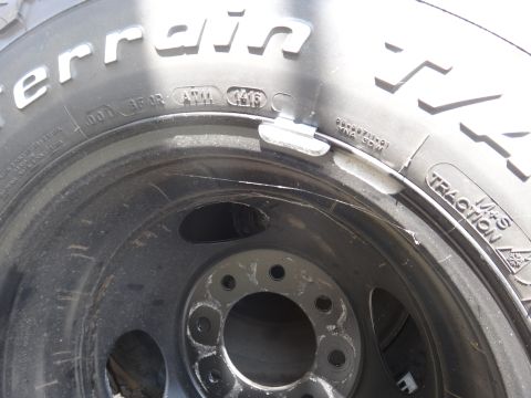 1995 Chevrolet P30 1 Ton - Step Van - A close-up view of a tire and wheel assembly, showing tire markings and a wheel weight.