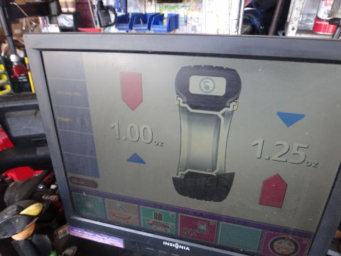 1995 Chevrolet P30 1 Ton - Step Van - A wheel balancing machine displays readings of 1.00 oz and 1.25 oz on its screen.