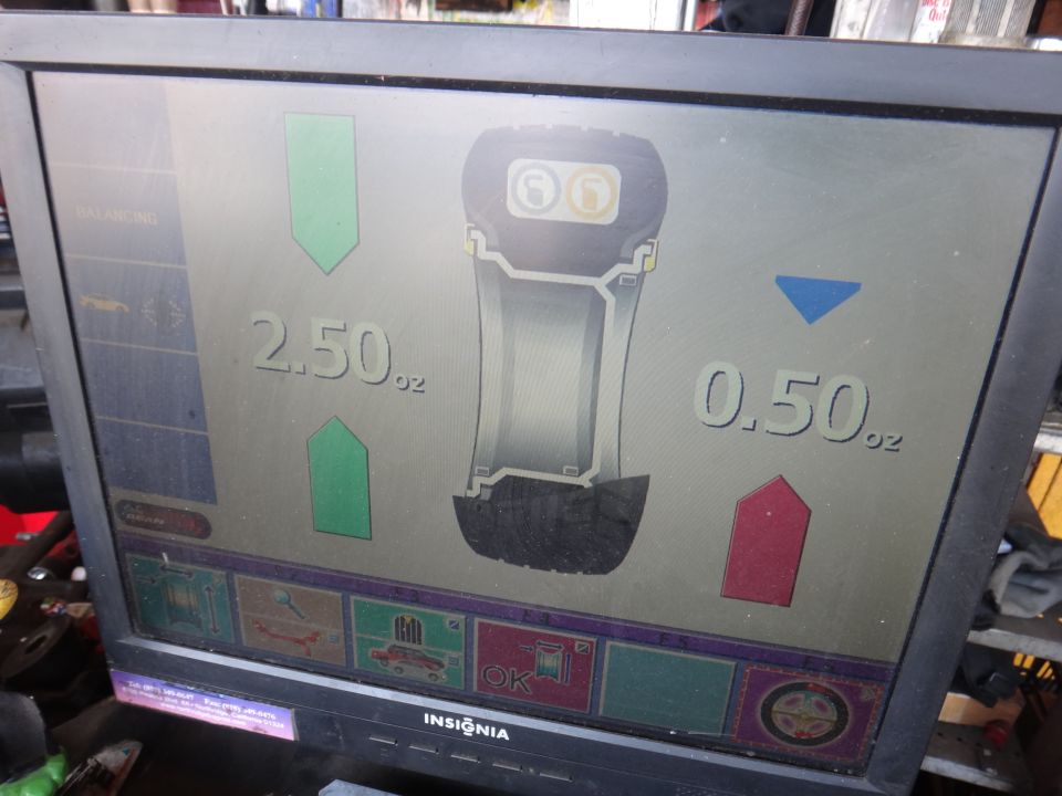Tire balancing machine screen showing 2.50 oz and 0.50 oz readings
