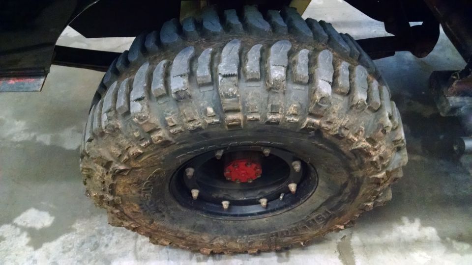 Close-up of a large, knobby off-road tire with a red hub and black wheel