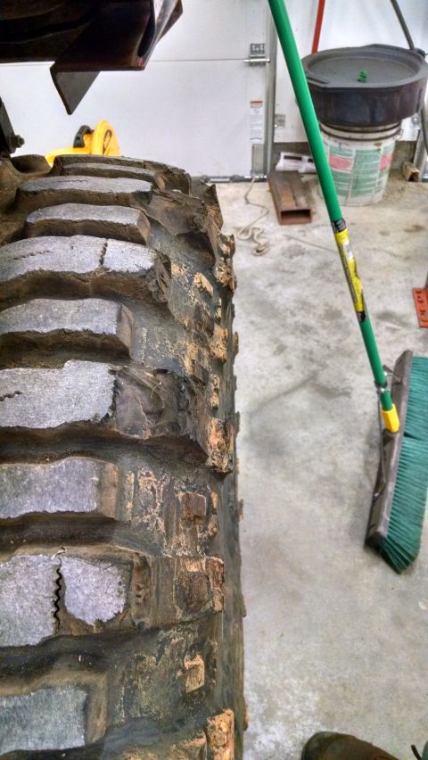 1995 Ford Bronco - This image shows a close-up view of a heavily worn off-road tire, revealing significant damage to its tread and sidewall.