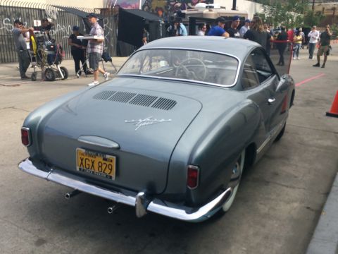 1968 Ford Mustang - A classic Volkswagen Karmann Ghia is parked outdoors with a film crew in the background.