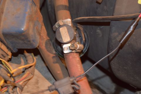 1978 Ford Bronco - Close-up of a heater hose connection with visible clamps and wiring.