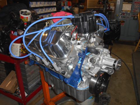 1972 Ford Bronco - A V8 engine with chrome valve covers and blue spark plug wires is mounted on an orange engine stand. The engine appears to be a Ford FE eng…