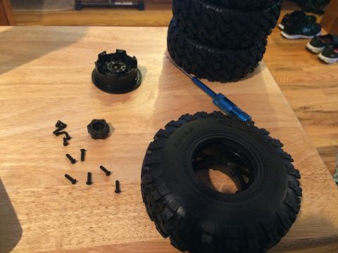 1989 Ford Bronco - A close-up view of donuts and donut holes arranged on a wooden surface, with hands in black gloves visible.
