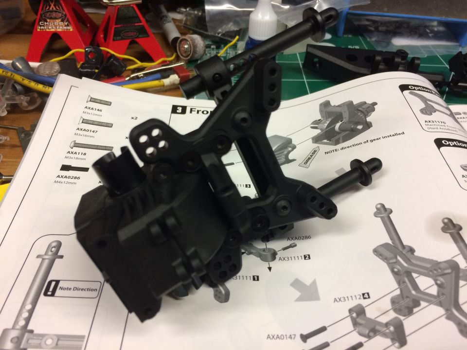 RC car gearbox assembly on top of instruction manual.