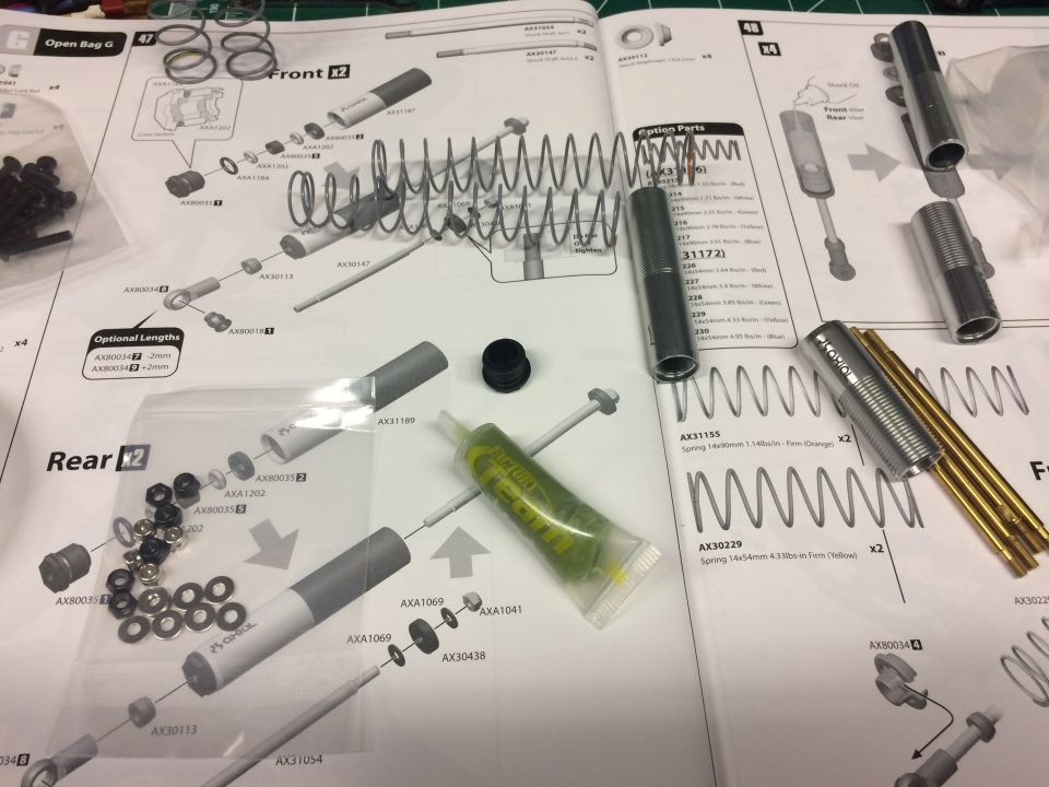 Axial RC kit Bag G front and rear shock exploded diagrams with parts laid out on the manual