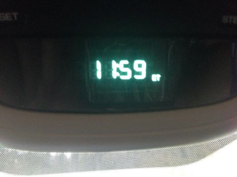 1979 Ford Bronco - A digital clock displays 11:59 PM on a vehicle's dashboard. The clock face is illuminated with green digital numbers.