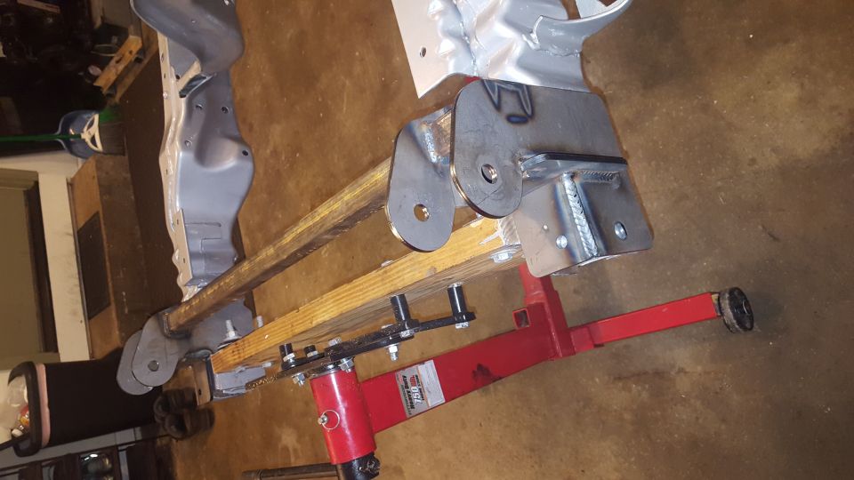 Custom fabricated steel suspension part on a red engine hoist.