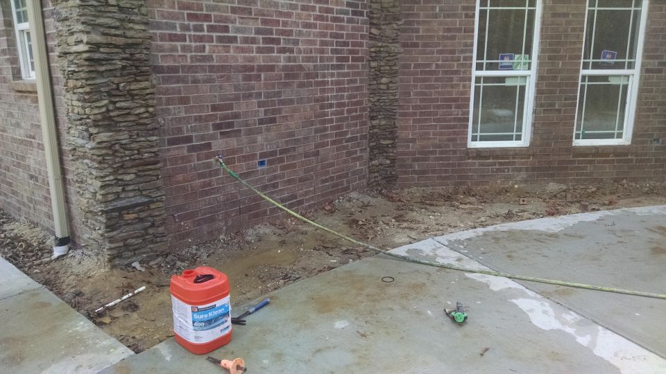 The mason is acid-washing the brick, but it's going to take at least another pass to remove all the extra mortar.