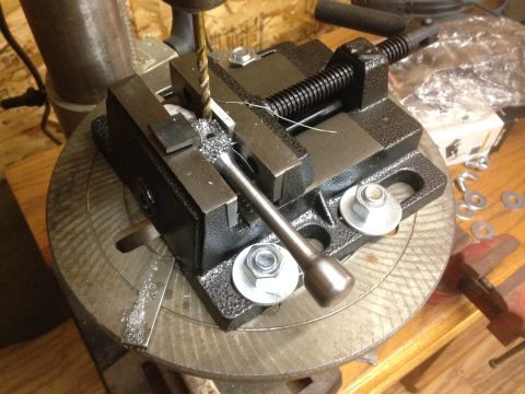 1979 Ford Bronco - A drill press is being used to drill into a metal workpiece held in a vise. The workpiece is mounted on a rotary table, and metal shavings…