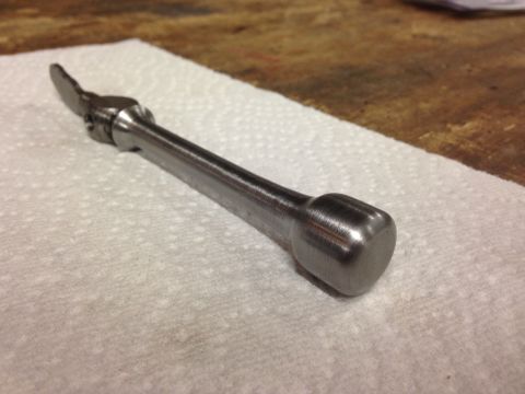 1979 Ford Bronco - A close-up shot of a metal tool with a ratcheting mechanism on one end and a rounded handle on the other, resting on a white paper towel.