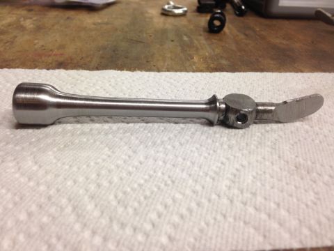 1979 Ford Bronco - A custom metal part, possibly a tool or component, is shown lying on a white paper towel. The part is metallic and has a brushed finish, wi…