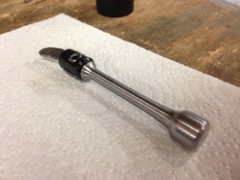 1979 Ford Bronco - A close-up view of a custom metal tool with a black grip and a curved blade, resting on a white paper towel.