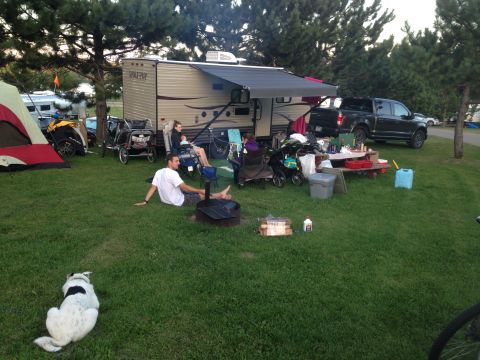 1979 Ford Bronco - A black Ford F-150 pickup truck is parked next to a campsite with a trailer, picnic table, and people enjoying the outdoors. The truck is p…