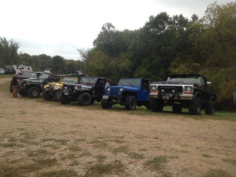 1979 Ford Bronco - A 1979 Ford Bronco is parked in a line with multiple Jeeps on a dirt lot.