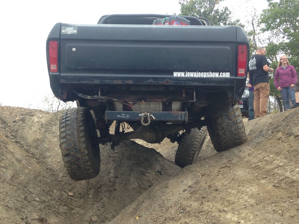 Black Ford pickup truck with large tires going off-road
