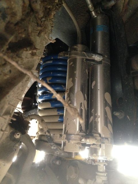 1979 Ford Bronco - Close-up view of off-road suspension components, covered in mud.