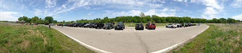 1979 Ford Bronco - A variety of vehicles are parked in a lot on a sunny day with scattered clouds.