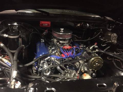1982 Ford Bronco - Customized engine bay blue valve covers and prominent red spark plug wires, with a SuperMotors watermark visible.