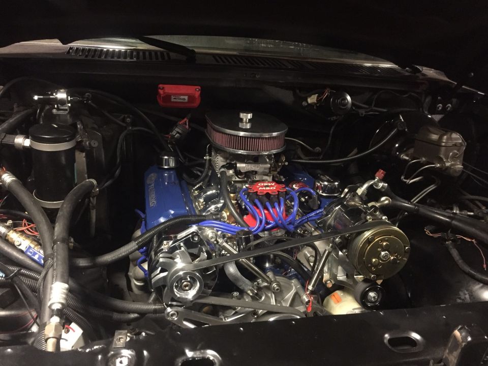 Engine bay with blue valve covers, red spark plug wires, and SuperMotors logo