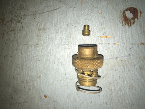 2014 Dodge 1500 - A brass valve assembly, including a spring and cap, is shown against a textured metal background. The Supermotors.net logo is visible in th…