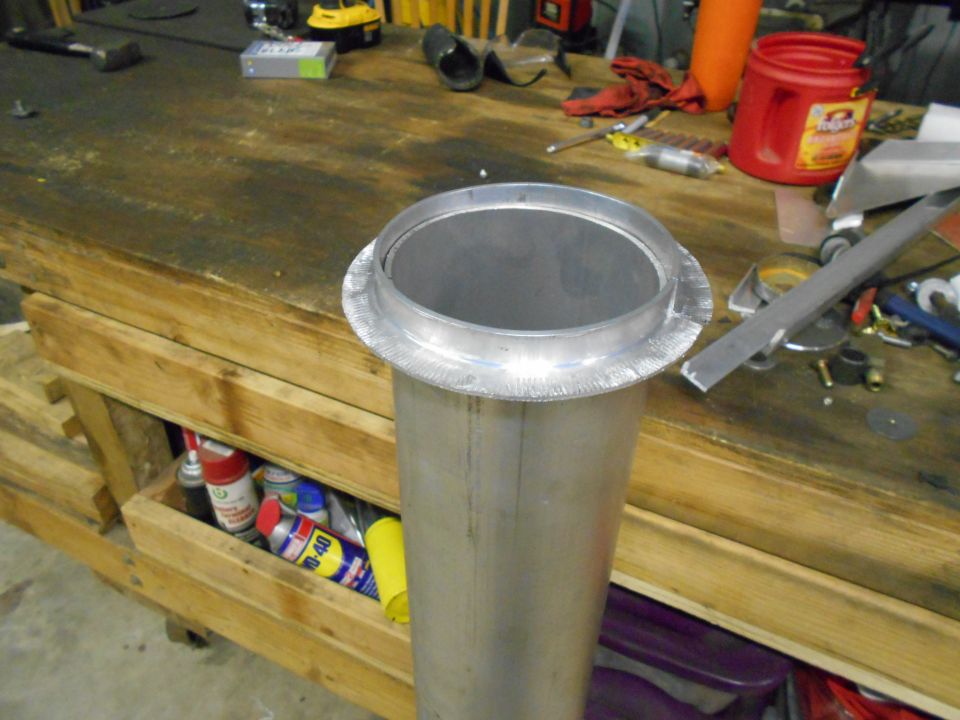 Metal pipe with flanged opening on workbench