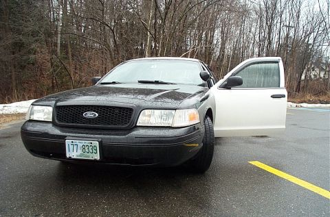 2001 Ford Crown Victoria - Front view of a black 2001 Ford Crown Victoria with the driver's door ajar.