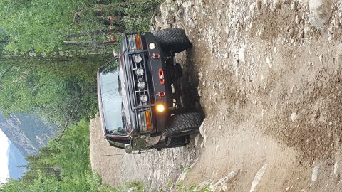 1996 Ford Bronco - This 1996 Ford Bronco navigates a challenging rocky trail, its off-road capabilities with a winch and auxiliary lights.