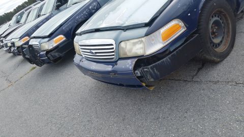 1991 Ford LTD Crown Victoria - Multiple Ford Crown Victoria police cars parked in a lot, showing front-end damage and wear.