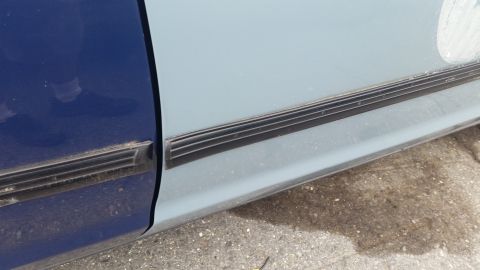 1991 Ford LTD Crown Victoria - Detail of car door trim showing a color transition and horizontal grooves.
