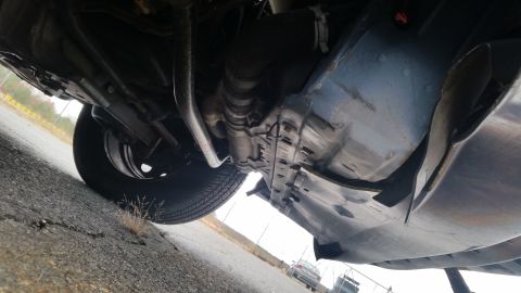 1991 Ford LTD Crown Victoria - This photo shows the underside of a vehicle, including the exhaust system and a tire.