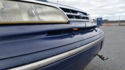 1991 Ford LTD Crown Victoria - Front corner view of a blue 1991 Ford Crown Victoria LTD showing damage to the bumper.