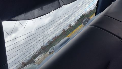 1991 Ford LTD Crown Victoria - Looking out from inside a vehicle at other cars parked in an outdoor lot on an overcast day.