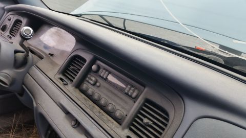 1991 Ford LTD Crown Victoria - The interior of a car shows a worn dashboard with a radio and gear shifter.