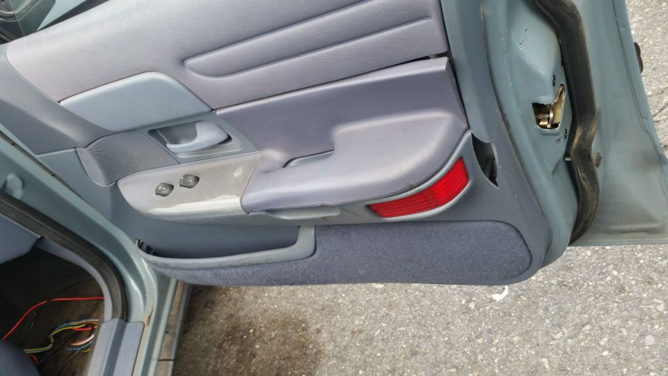 1991 Ford Crown Victoria LTD interior door panel with power window switches and red reflector