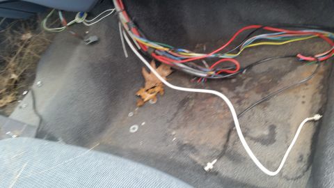 1991 Ford LTD Crown Victoria - The floor of a vehicle interior shows a tangle of wires and debris, with some rust visible.