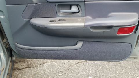 1991 Ford LTD Crown Victoria - Interior of a car door panel, showing the armrest, window controls, and door handle.