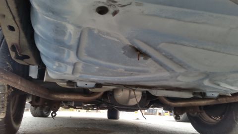 1991 Ford LTD Crown Victoria - The underside of a vehicle is visible, with exhaust pipes and a differential clearly seen.