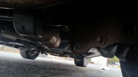 1991 Ford LTD Crown Victoria - The underbody of a vehicle is shown, with focus on the exhaust and suspension parts.