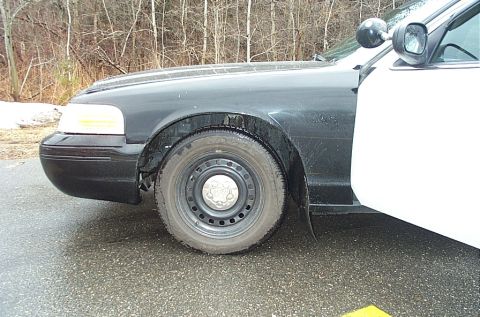 2001 Ford Crown Victoria - Side view of a 2001 Ford Crown Victoria police car, showing the front fender and door.