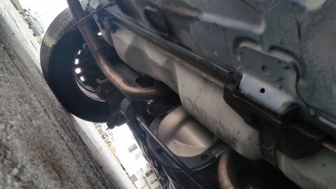 1991 Ford LTD Crown Victoria - Underside view of a car's drivetrain components including the exhaust and differential.